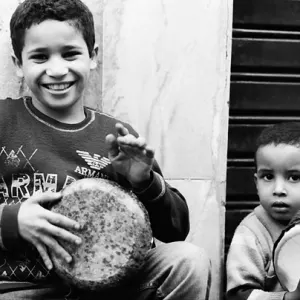 Boys hitting drum in lane