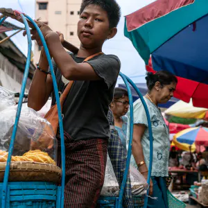 Young man carrying blue baskets