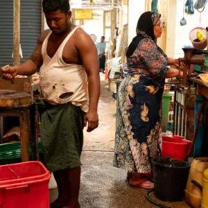 Two persons working back to back in butcher