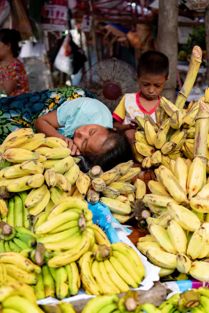 Mother sleeping on the other side of the pile of bananas