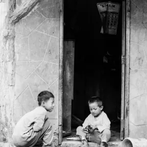 Two boys playing in front of house