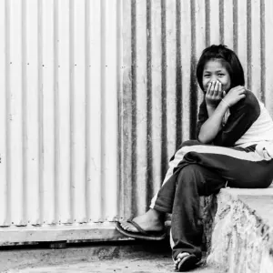 Cross-legged girl waiting for bus