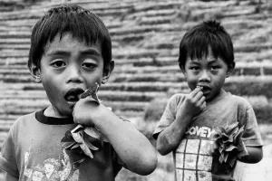 Boys biting leaf