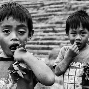 Boys biting leaf