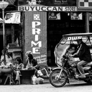 Tricycle stopping in fornt of street vendor