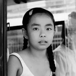 Girl sitting on window seat of a bus