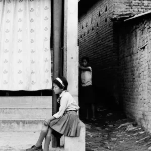 School girl sitting by roadside