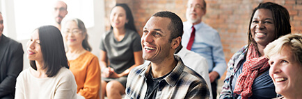 Group of people sitting and smiling at an education and training event