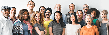 Large, diverse group of people standing close together and smiling