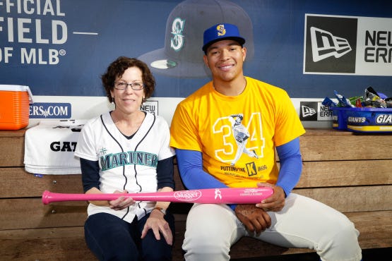 Honorary Bat Girl Betsy Haffner and pitcher Taijuan Walker with her personalized Louisville Slugger pink bat.