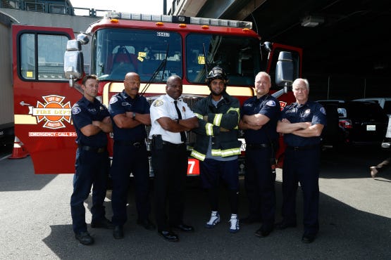 Nelson Cruz poses with Seattle Fire Fighters and Chief Harold Scoggins. The photo will be part of a social media campaign to help SFD win a $10,000 Medic One grant.