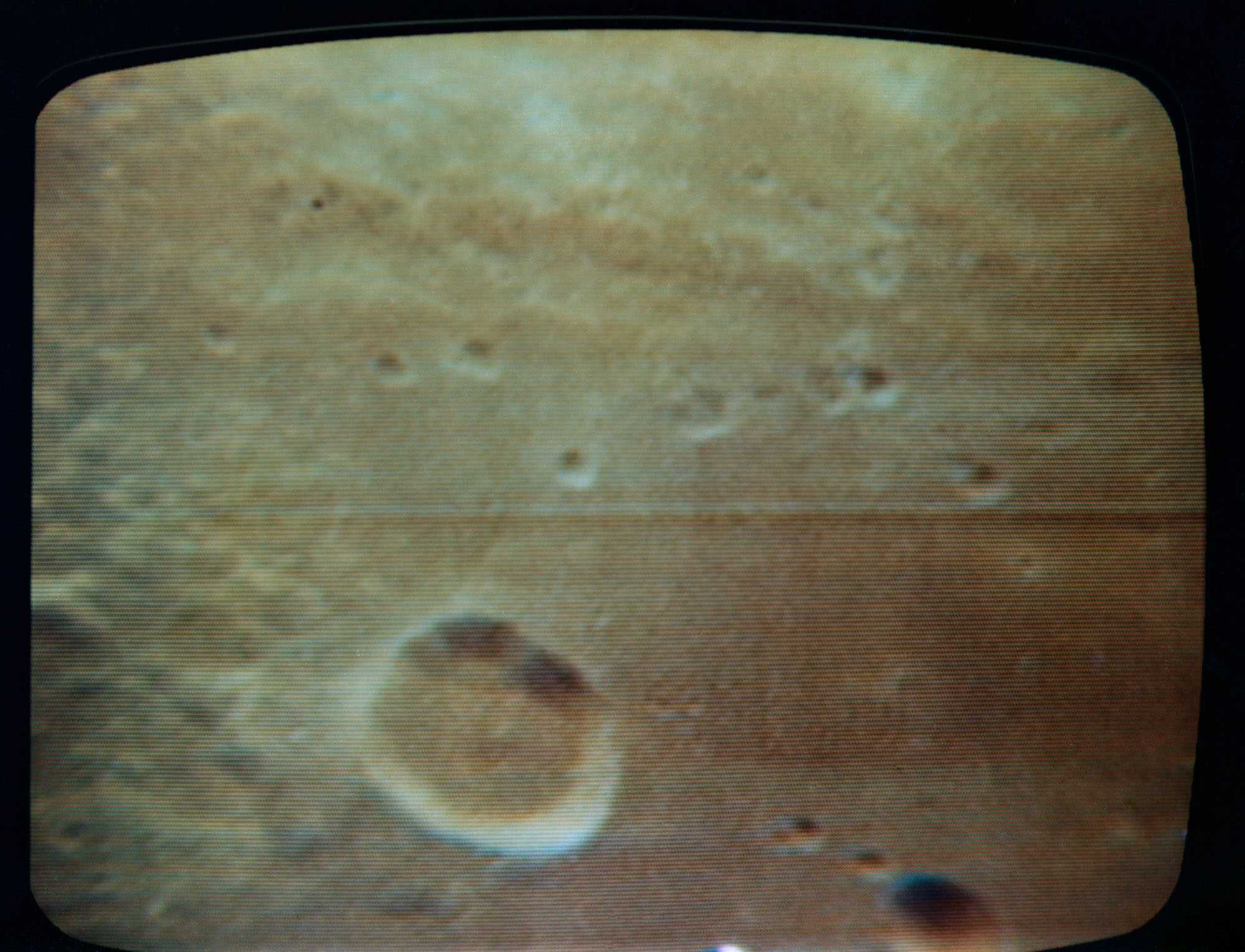 This close-up (full zoom) view of the Sea of Fertility is seen, in this color reproduction taken from the fourth television transmission, from the Apollo 11 spacecraft during its second revolution of the moon on July 19, 1969. This live TV broadcast from 