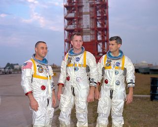 From left, Apollo 1 astronauts Virgil I. Gus Grissom, Edward White and Roger Chaffee pose in front of their Saturn 1 launch vehicle at Launch Complex 34 at the Kennedy Space Center. The astronauts later died in a fire on the pad.