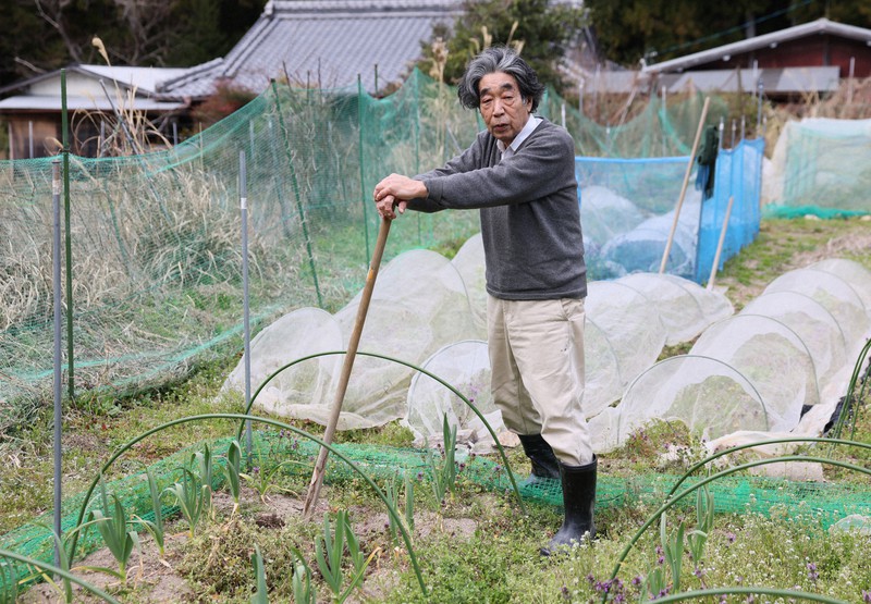 自宅前の畑に立つ秋山豊寛さん＝三重県大台町で2023年3月16日、兵藤公治撮影