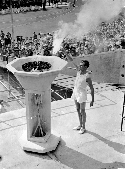 May 1948: A British athlete bears the Olympic Torch into the Empire Stadium at Wembley, London, and inaugurates the 1948 Olympic Games by lighting the ceremonial flame.  (Photo by PNA Rota/Getty Images)