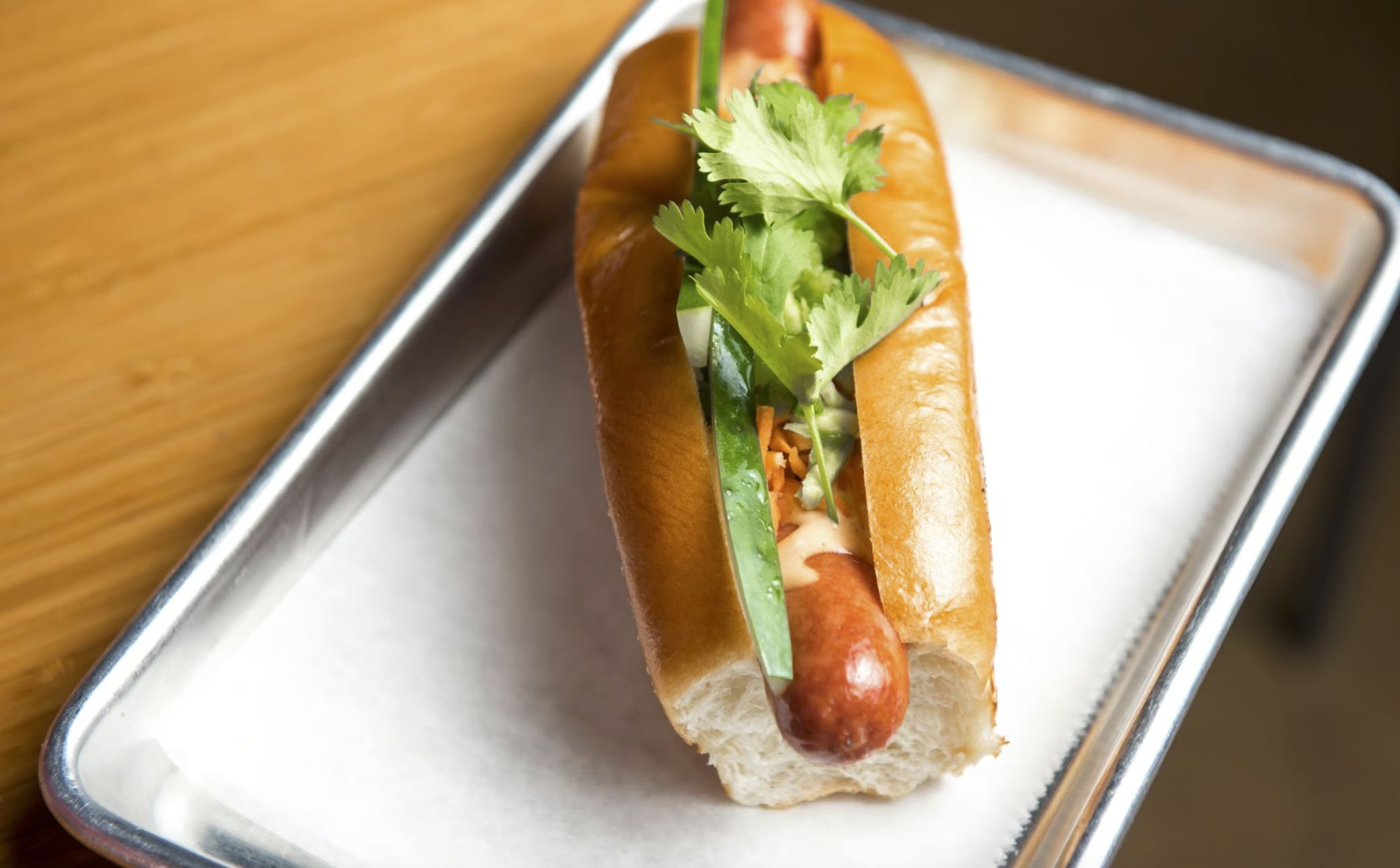 a hot dog on a silver tray