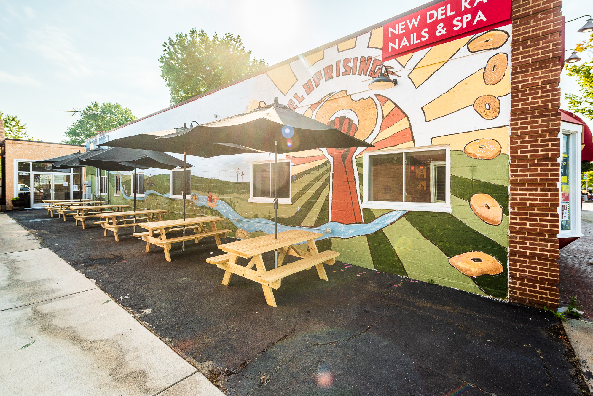 The patio at Bagel Uprising features a fresh mural