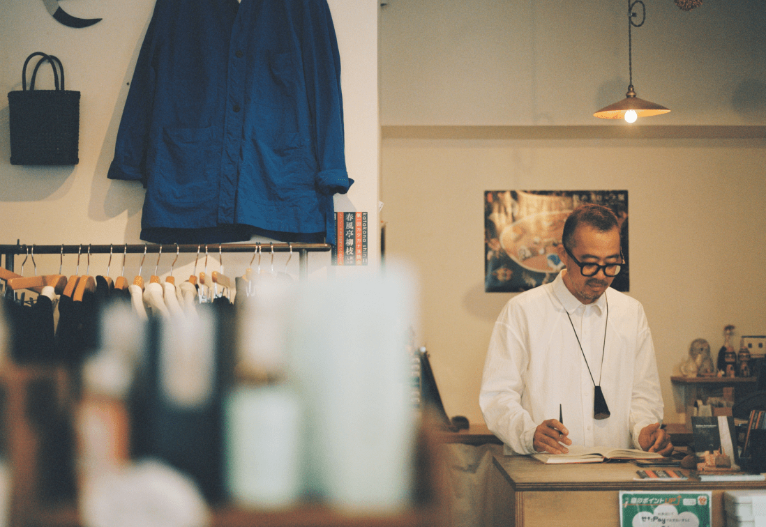 店内でノートを見つめる男性。