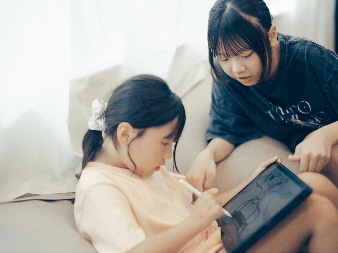 タブレットを見つめる2人の女の子。