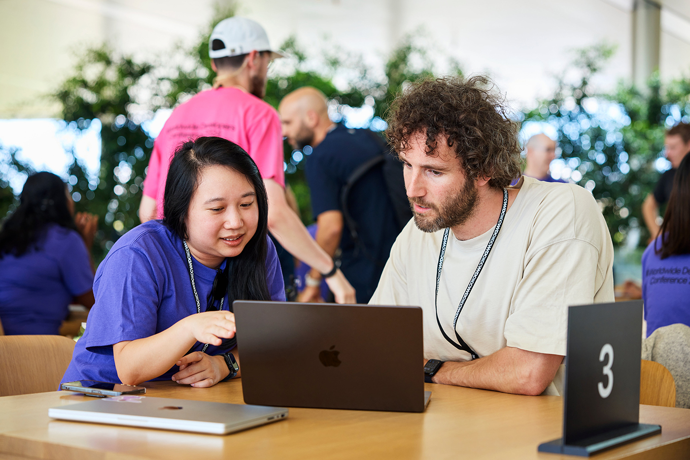 A photo of an Apple team member working with a developer on a MacBook at Apple Park during WWDC24.