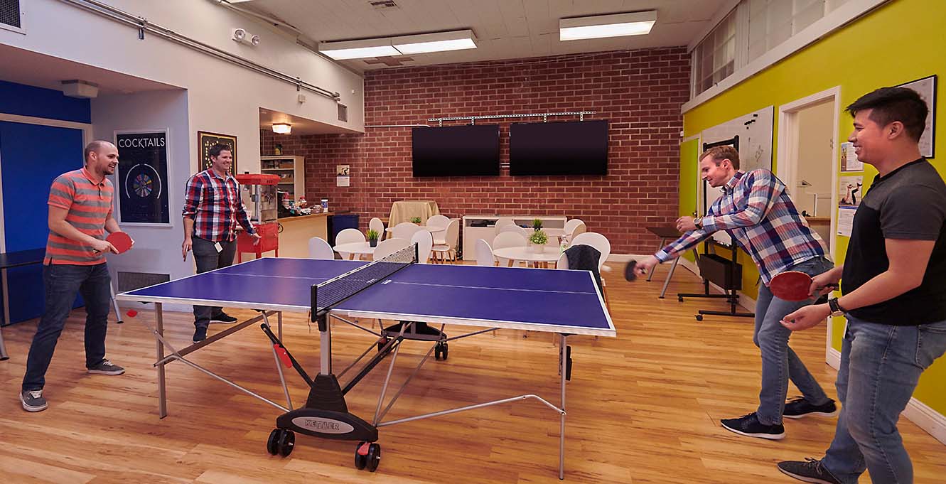 four people playing ping pong