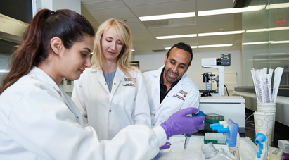 Work at McMaster - Group of McMaster students in white lab coats conducting science experiment