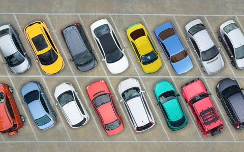 multicoloured cars parked in two diagonal rows