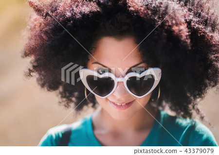 Sensual portrait of young pretty woman with african curly hairstyle and heart-shaped sunglasses 43379079