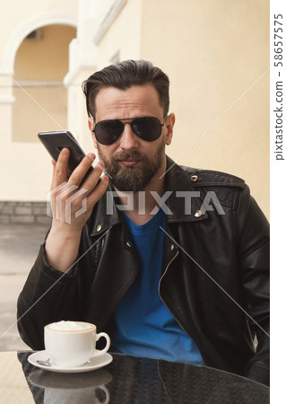 Trendy man on summer terrace cafe with smartphone 58657575