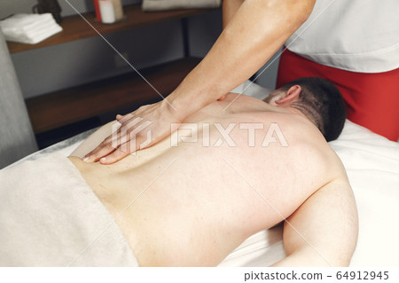 The doctor massages the man in the hospital 64912945