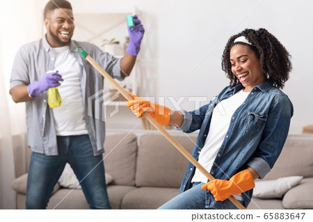 Spring-Cleaning Fun. Joyful African Couple Fooling Together While Tidying Their Apartment 65883647