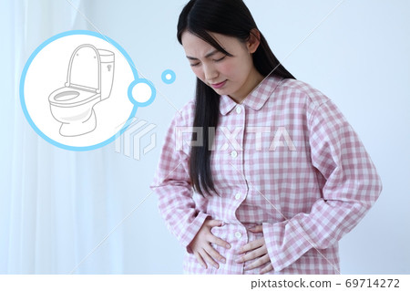 Image of a woman in pajamas with a stomachache 69714272