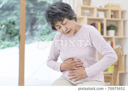 Senior woman with abdominal pain 70975652