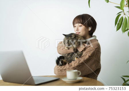 A woman whose work is disturbed by a cat 75323153