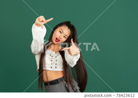 Asian young woman's portrait isolated over color studio background with copyspace 78423612