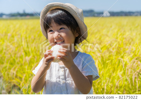 A girl chewing onigiri 82175022