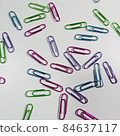 Scattered colorful paper clips 84637117