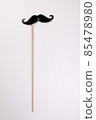 Black moustache shape paper die cut selfie portrait party fun paper prop sticker stick on white background  85478980