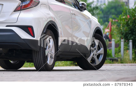 Close up of a car parked on city street side. 87978343