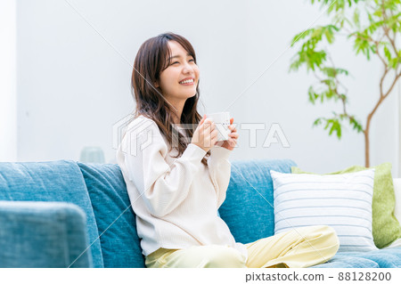 Young woman drinking coffee in the living room 88128200