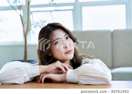 A smiling young woman relaxing in the living room 89762993