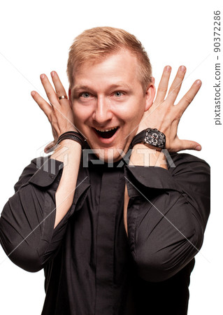 Young blond man in a black shirt, watches and bracelet is making faces, isolated on a white background 90372286