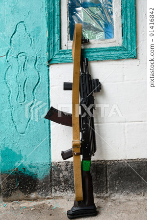 The Ukrainian soldier's combat military assault rifles AK 74 is leaning against the wall in the house, the war in Ukraine. 91416842