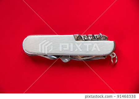 Metallic swiss knife isolated on red 91468338