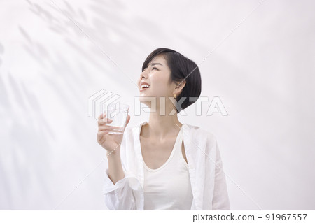 Young woman drinking water in the living room 91967557