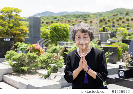 Senior woman visiting a grave 91356933