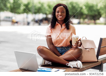 african student girl with coffee, laptop and books 93472258