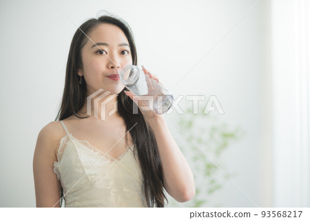 Japanese woman in her twenties drinking water from a water bottle 93568217