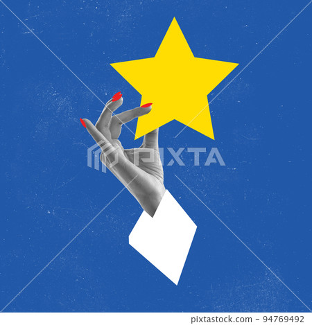 Contemporary art collage. Female hand holding big yellow star over blue background. Good luck symbol 94769492