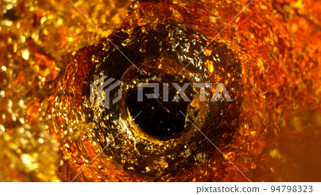 Freeze Motion Shot of Golden Liquid Whirl Isolated on Black Background 94798323